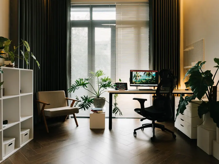 A desk in a plant-filled home office